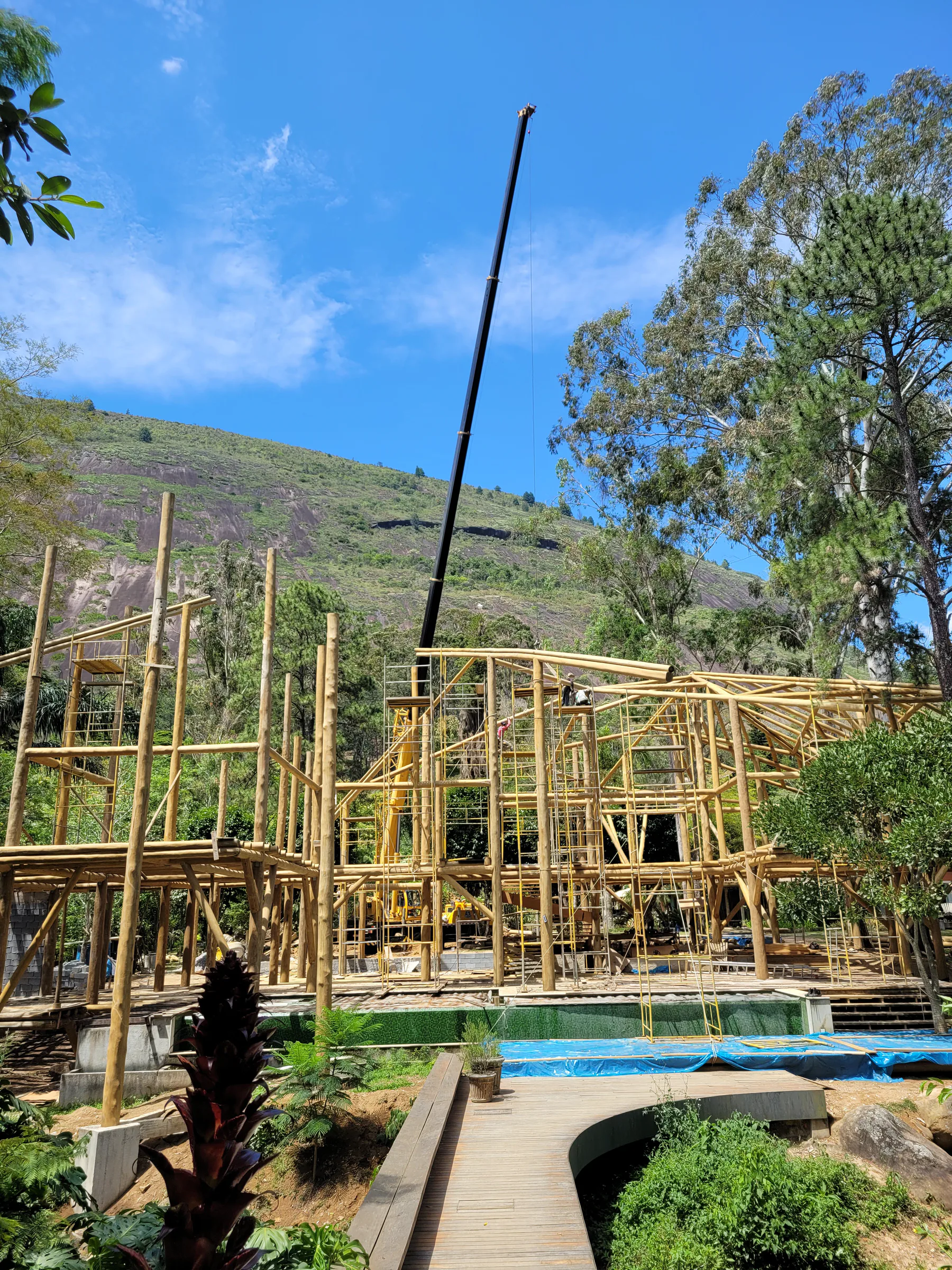 Trama de toras de eucalipto roliço da Casa Paraqueira Araras diante da paisagem serrana