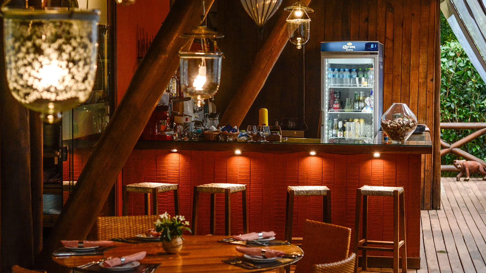 Bar sob pilares, vigas e cobertura de madeira no restaurante da Pousada Triboju em Fernando de Noronha