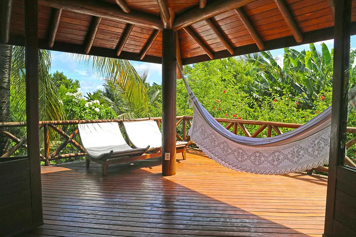 Varanda de bangalô com deck, guarda-corpo e telhado de madeira na Pousada Triboju em Fernando de Noronha